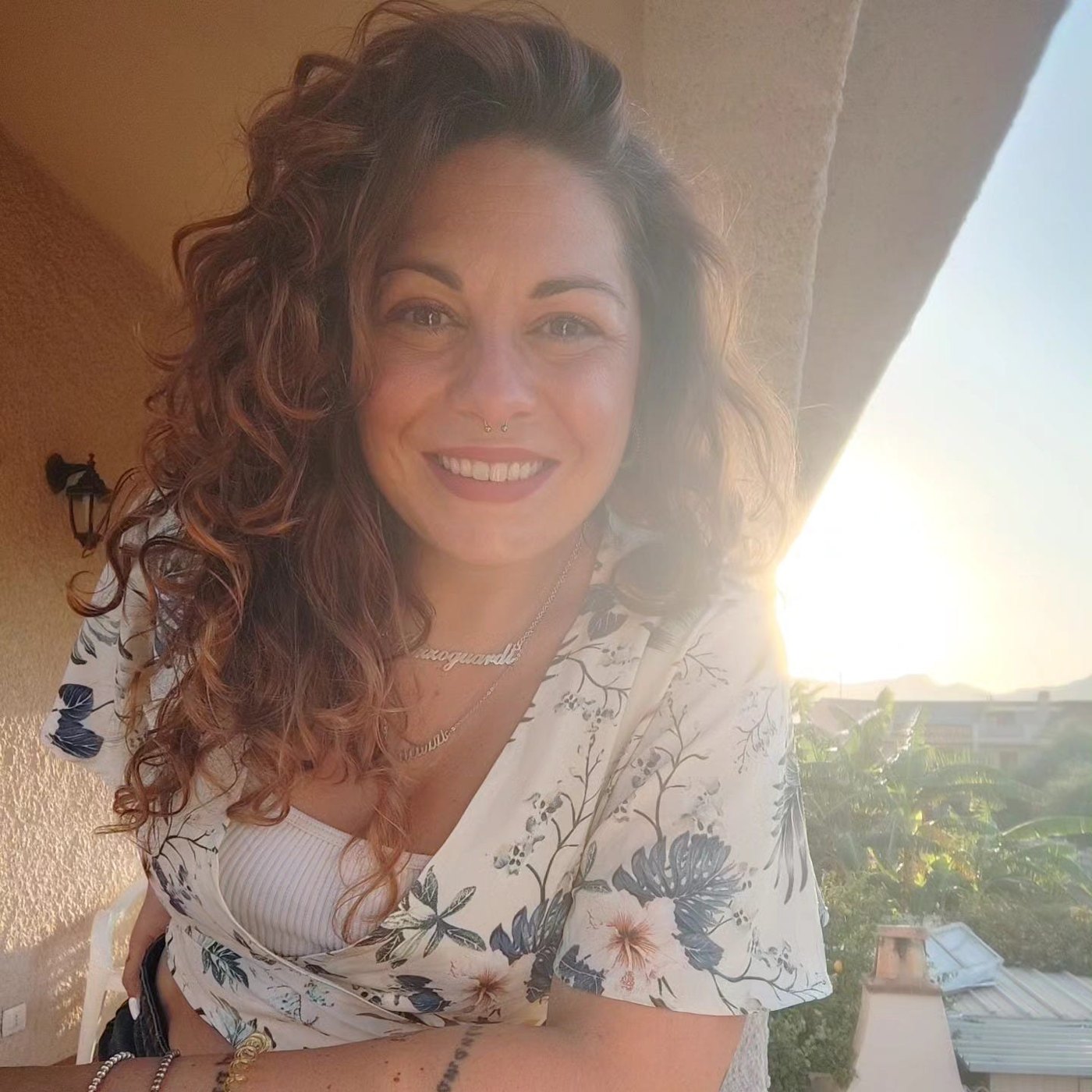 Ritratto di Charlotte Matteini, sorridente, su un balcone al sole